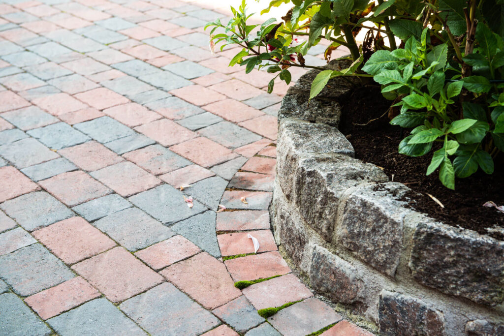 a circular raised flowerbed made of granite setts