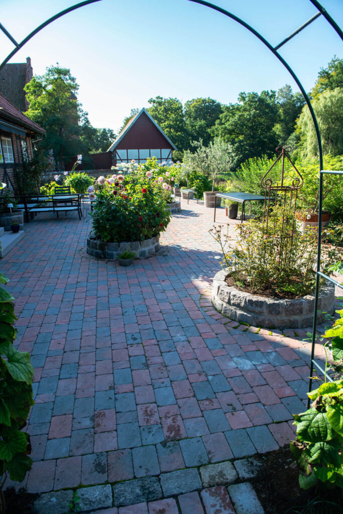 a circular raised flowerbed made of granite setts
